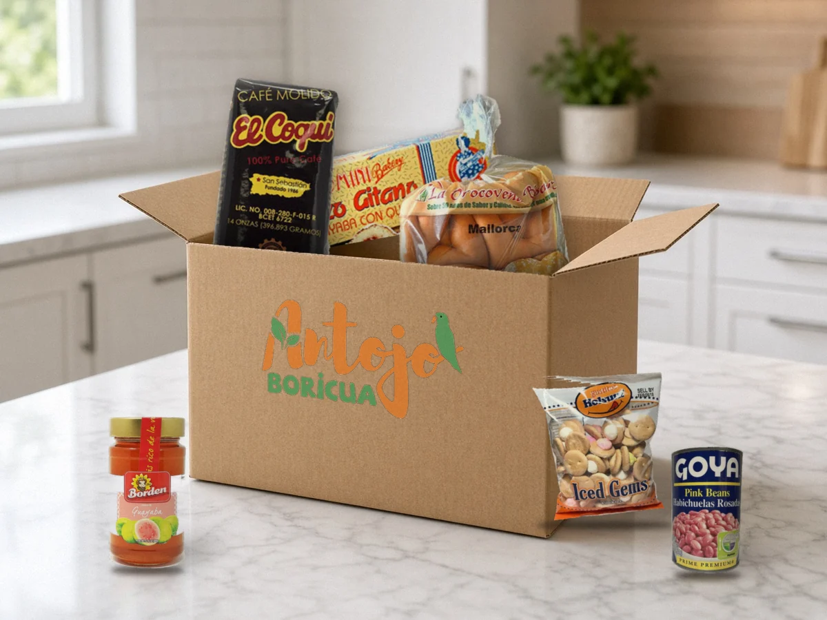 Open Antojo Boricua box packed with Puerto Rican products: Café El Coquí, Brazo Gitano Ricomini, Mallorcas La Orocoveña, Holsum Florecitas, Goya pink beans and Borden guava jelly